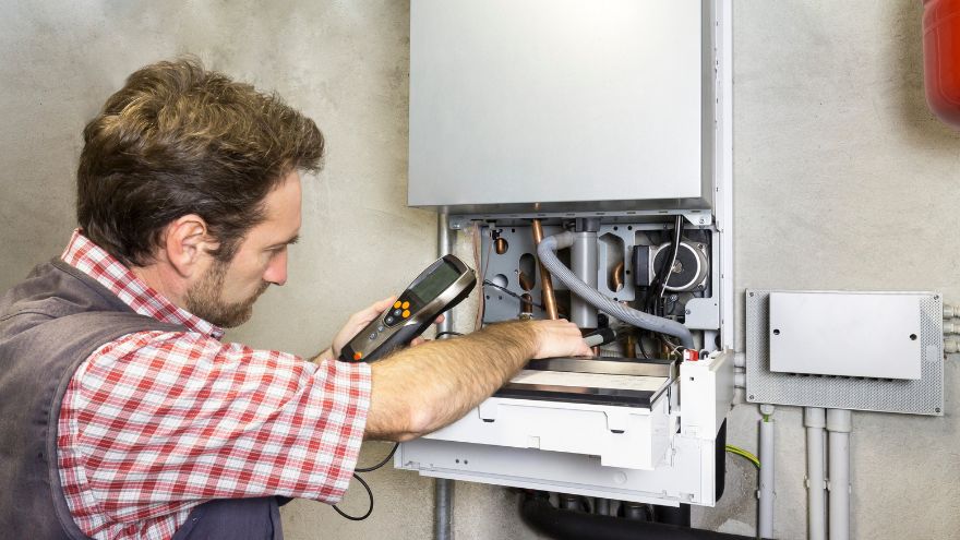 Instalator sprawdza napięcie w piecu gazowym kondensacyjnym