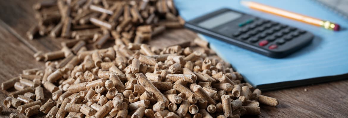 Pellet rozsypany na stole, obok znajdują się kalkulator, zeszyt i ołówek