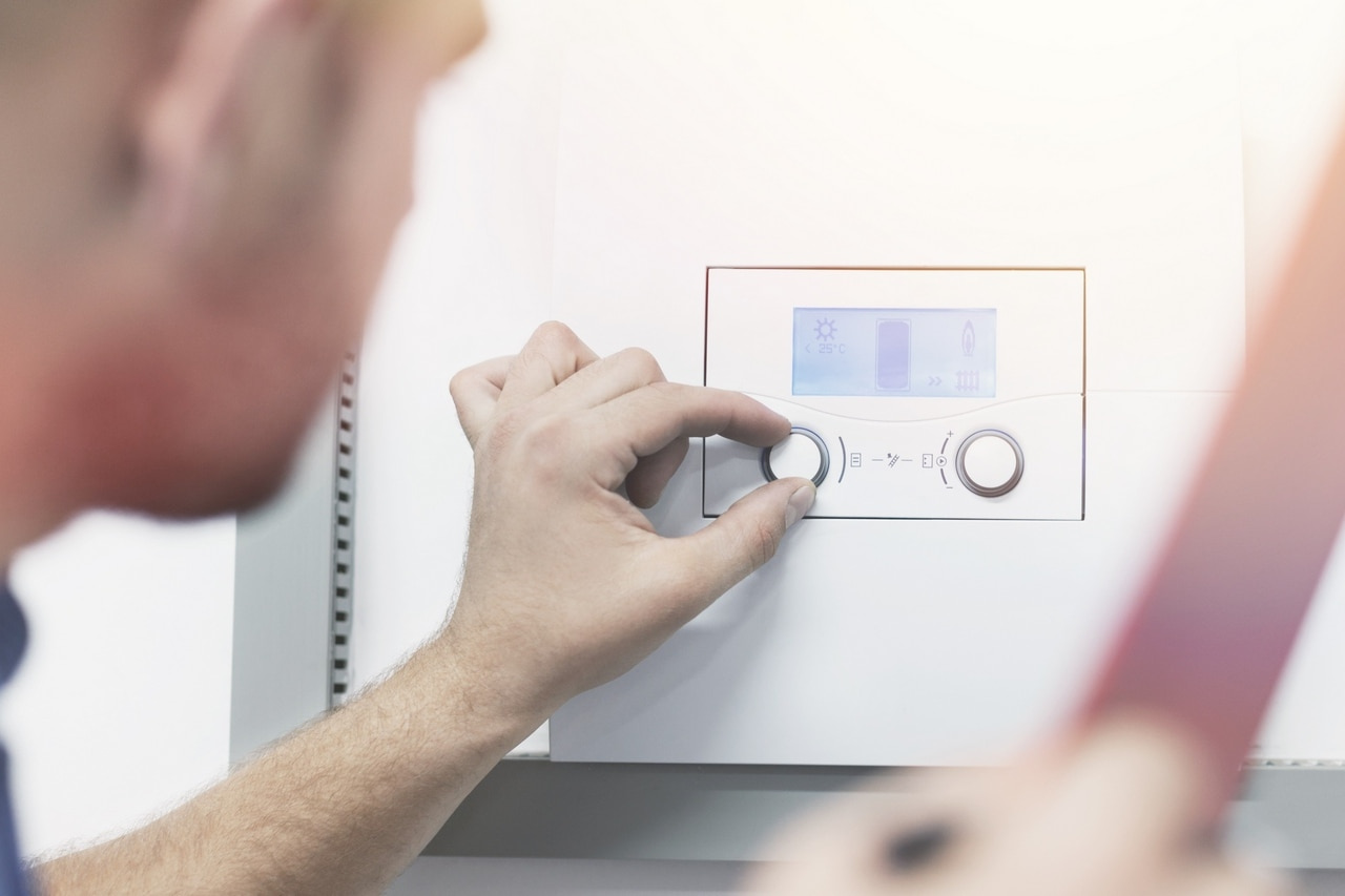 Mężczyzna zmieniający ustawienia kotła elektrycznego.