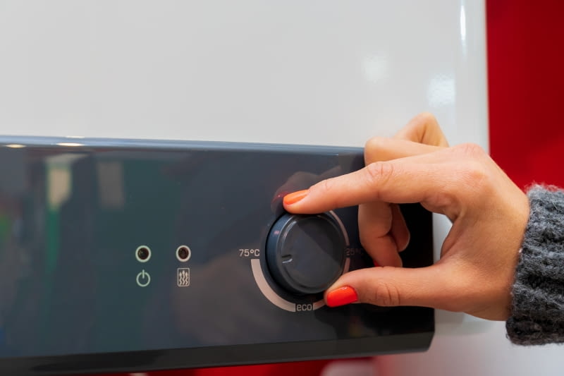 Kobieca dłoń zmieniająca ustawienia kotła elektrycznego